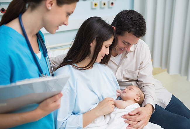 Image of a mother and father with their newborn baby in a hospital delivery room