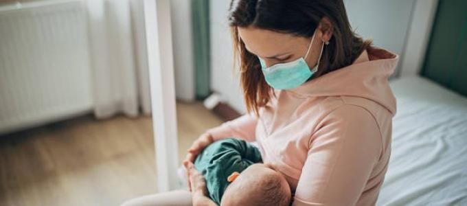 Mom with Mask Holding Baby